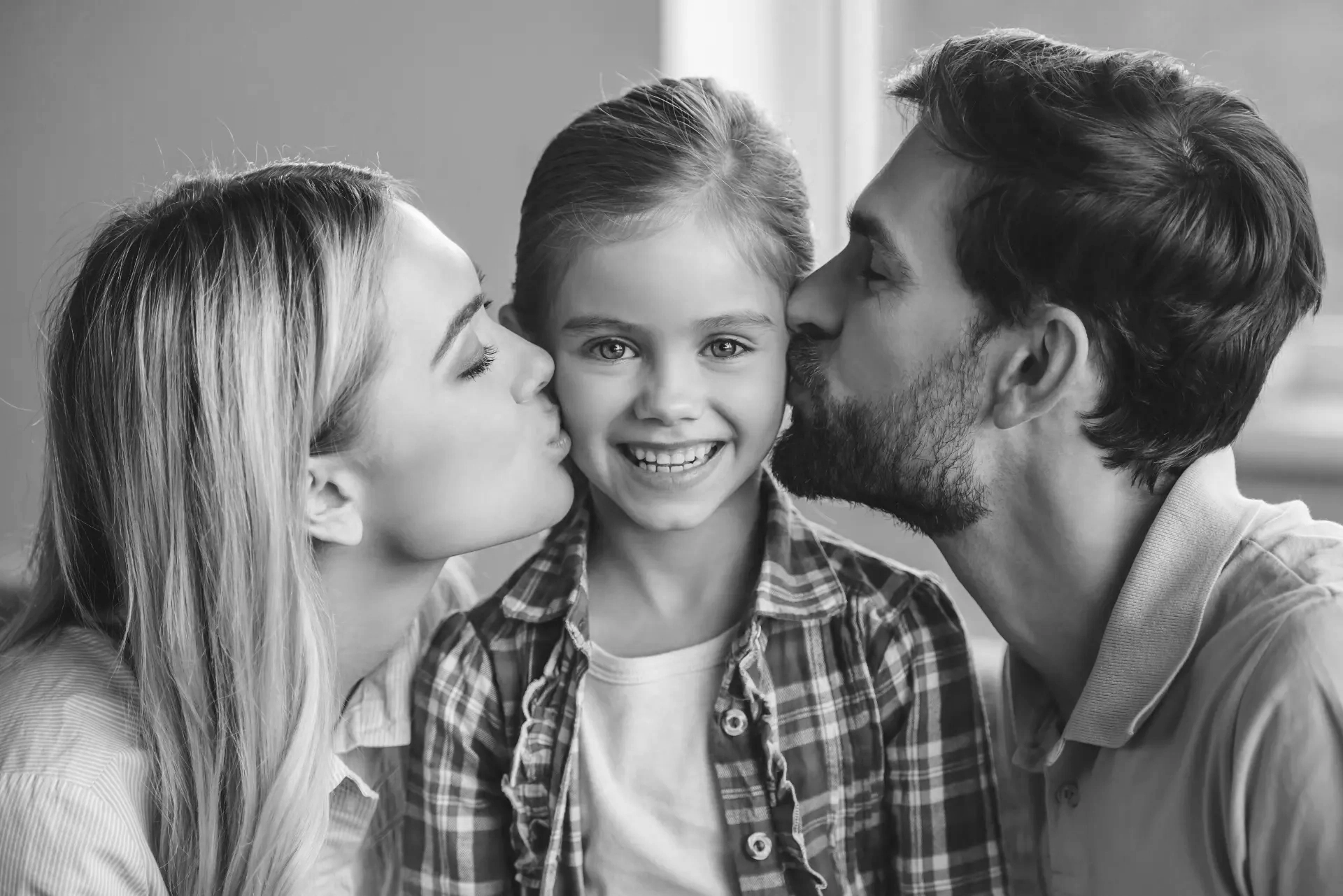 beautiful-young-parents-are-kissing-their-cute-little-daughter-who-is-looking-camera-smiling