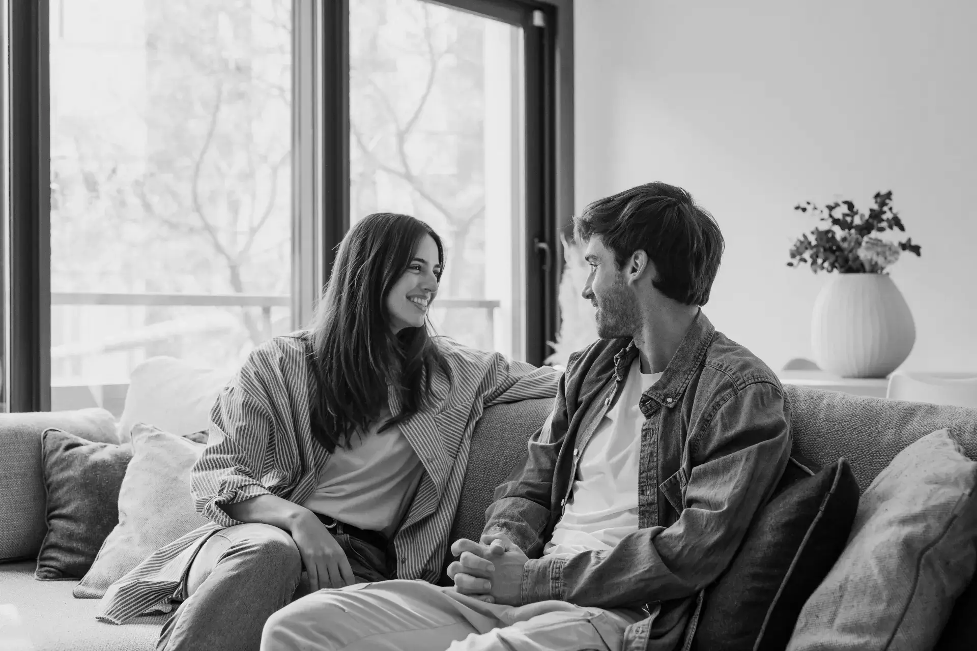 young-happy-couple-having-fun-talking-laughing-relaxing-home-couch-boyfriend-embracing-girlfriend-telling-funny-joke-sitting-sofa-humor-relationships-enjoying-weekend-togetherxa